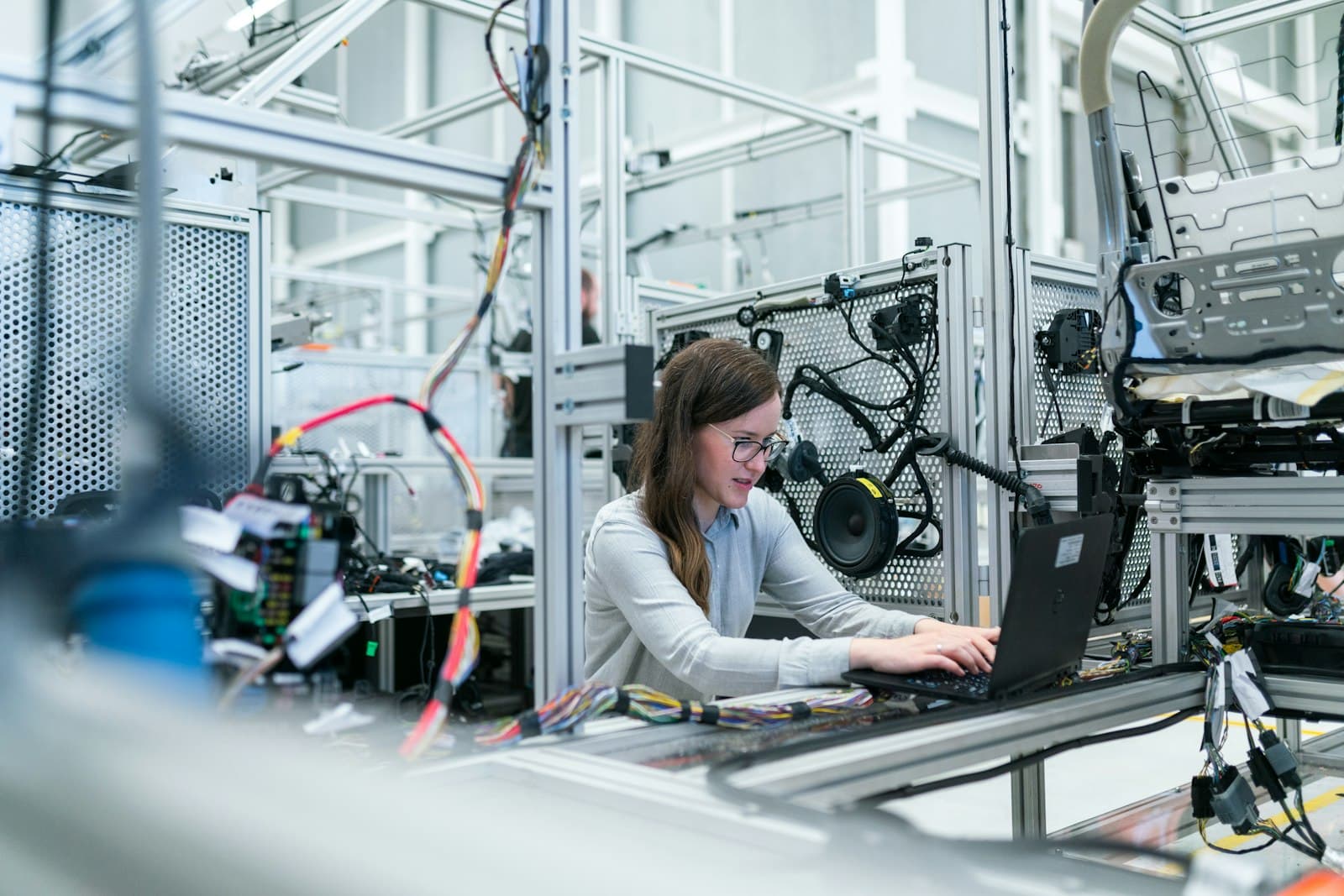 An engineer working at a laptop on the factory floor